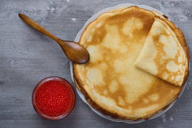 Gri bir masada kırmızı havyarlı Rus gözlemeleri.