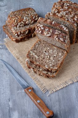 Kesme tahtasında dilimlenmiş çavdar ekmeği. Tohumlu tam tahıllı çavdar ekmeği.