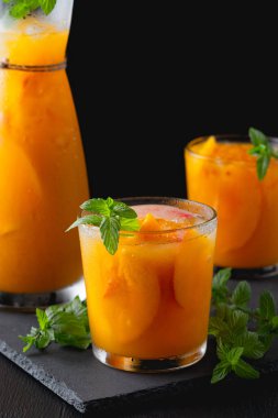 Şeftalili limonata, siyah masa arkaplanlı kokteyl. Yaz içeceği