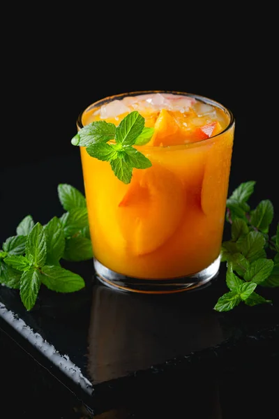 Limonada de pêssego, coquetel em um fundo de mesa preto. Bebida de verão — Fotografia de Stock