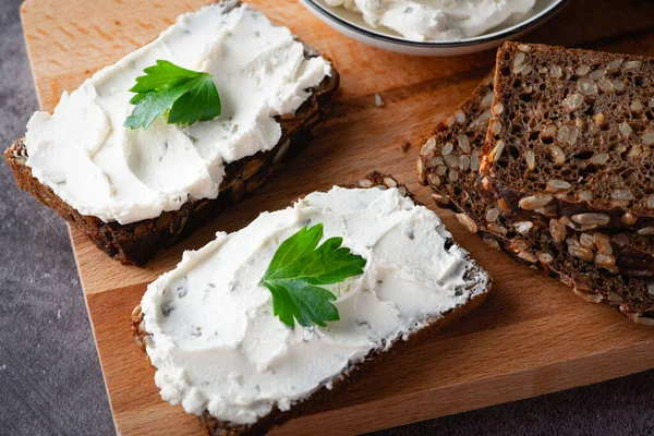 Rågbröd med färskost på grått bord. fullkornsrågbröd med frön — Stockfoto