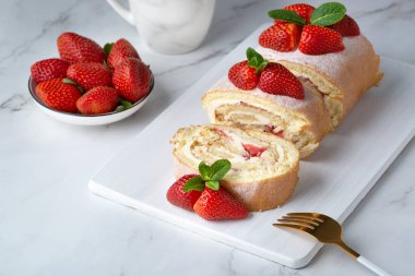 Çilekle doldurulmuş tatlı rulo ve çilekle süslenmiş krema