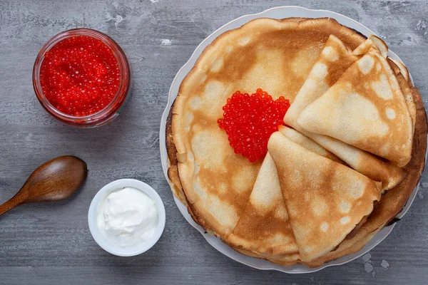 Montón de panqueques finos rusos blini con caviar rojo y crema agria fresca —  Fotos de Stock