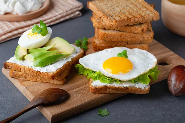 Peynirli sandviç, sahanda yumurta, avokado ve otlar. — Stok fotoğraf