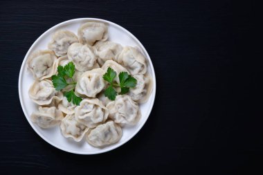 Geleneksel Rus pelmeni, ravioli, siyah arka planda etli börek. Üst Manzara. Boşluğu kopyala