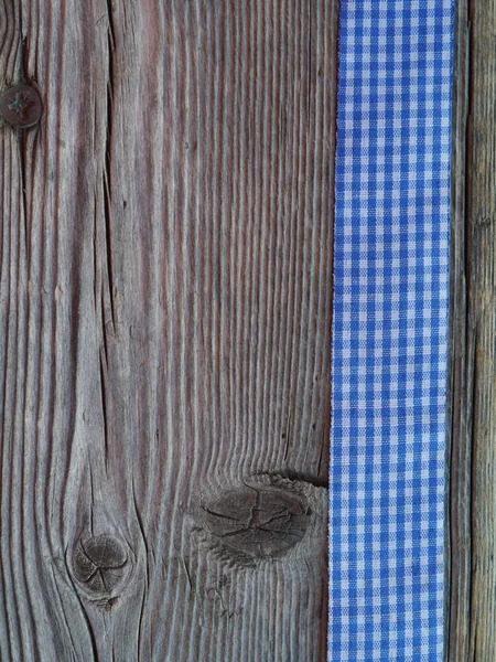 Wooden background with a checked ribbon — Stock Photo, Image