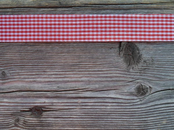Wooden background with a checked ribbon — Stock Photo, Image