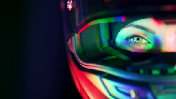 Mitad mujer atractiva motociclista cara de mujer en casco de motocicleta. Macro vista de los ciclistas ojo con resplandeciente luz de colores de neón. Viaje, corredores de café, velocidad, concepto de libertad. Copiar espacio. — Vídeos de Stock