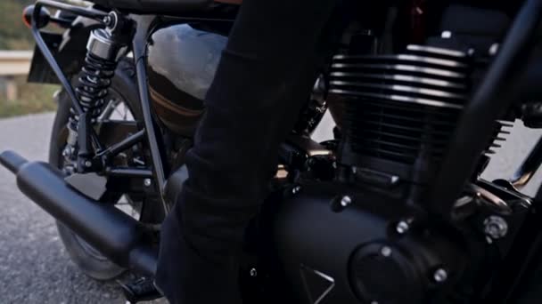 Eine unkenntliche Motorradfahrerin im Minirock sitzt auf einem Motorrad im Retro-Stil. Sexy Fahrerin in Jacken auf der Fahrbahn. Reise, Geschwindigkeit, Freiheitskonzept. — Stockvideo