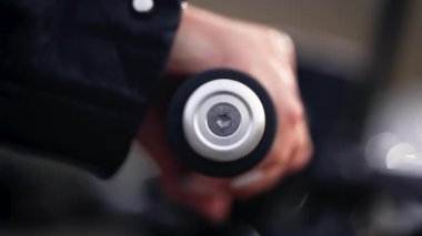 Dişi motosikletçi, şehirde dikilirken ivmeölçer kolu büker. Klasik kafe yarışçılarının kültür ve estetiği, klasik motosiklet.