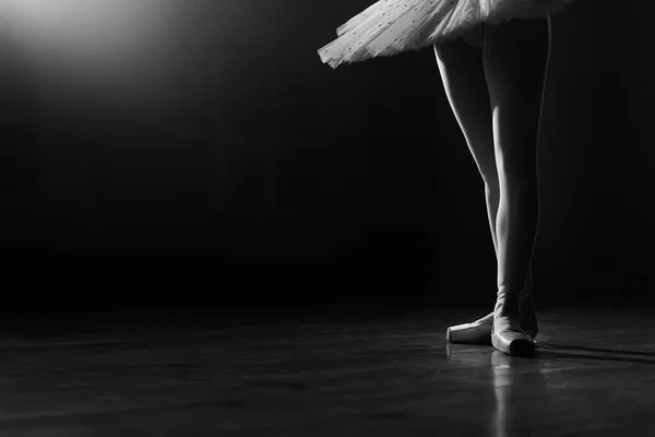 Ballet dansers benen in puntschoenen op theater podium. Ballerina staat in 3 derde positie op zwart-witte achtergrond. Mooie vrouwenvoeten. Lady toont klassieke pas. Kopieerruimte. — Stockfoto