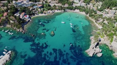 Göl kıyısına açık mavi deniz suyuyla hava aracı görüntüsü. Cennet adası. Lüks tatil köyleri, tekneler, yatlar. İnanılmaz Avrupa deniz manzarası.