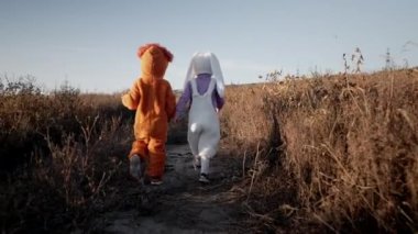 Güzel çocuklar eğleniyor. Sonbahar doğasında yürüyen çocuklar. Aslan ve tavşan kostümlü küçük arkadaşlar. Cadılar Bayramı, şeker mi şaka mı? Aile, mutluluk, kardeş kavramı.