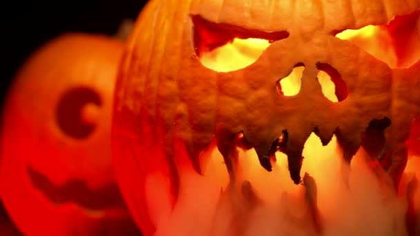 Skrämmande snidade halloweenpumpor med rök. Trick eller behandla bakgrund. Glödande ansikte med lågor inuti. Symbol för Allhelgonaafton. Långsamma rörelser — Stockvideo