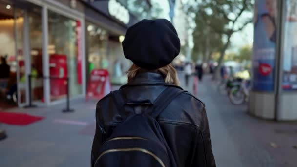 Joven mujer irreconocible camina por la concurrida calle de la ciudad con la mochila en los hombros. La estudiante regresa después de clases de la universidad. Senora turista caminando sola en Europa. — Vídeo de stock