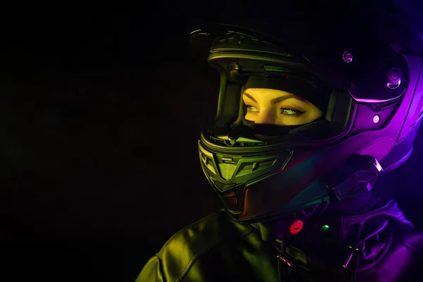 Retrato de mulher motociclista confiante em capacete de motocicleta fechado. Motociclista jovem motorista sob luz de néon colorido à noite. Espaço de cópia. — Fotografia de Stock