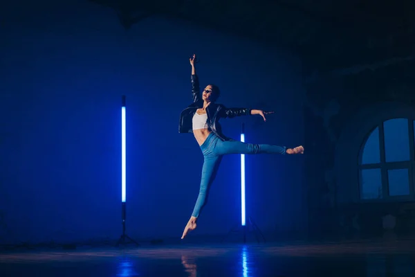 Giovane donna in stile casual jeans e giacca di pelle che fa balletto in studio moderno. Pratiche di ballerina attraenti solo nella coreografia — Foto Stock