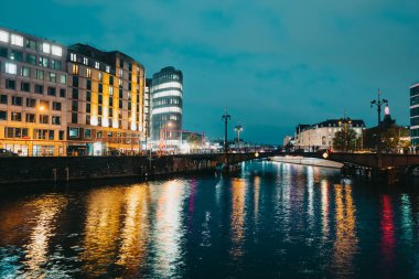 Ekim 2021 - Berlin, Almanya. Gece görüşünden tarihi işlek caddeye, Spree nehrinin altındaki köprüye. Uzun pozlama, Alman başkentinde Friedrichstrasse trafiği.