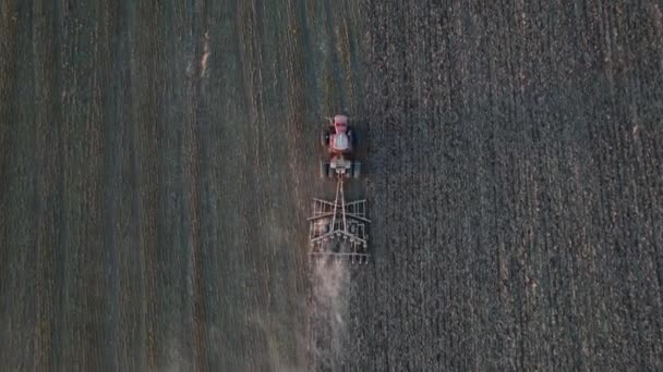 Luftaufnahme von Landmaschinen, die auf bestellten Feldern arbeiten. Saatgut oder erschütterndes Konzept. Moderner landwirtschaftlicher Traktor, der den Boden für die Aussaat vorbereitet. Drohnenaufnahmen. — Stockvideo