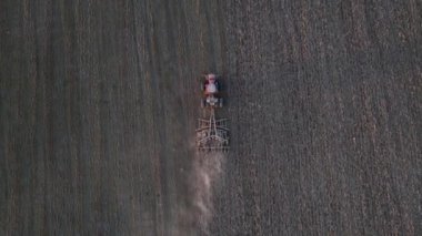 Hasat topladıktan sonra tarlayı süren traktörün drone görüntüsü. Tarımsal doğal mevsimsel çalışmaların havadan görünüşü. Üzücü bir kavram.