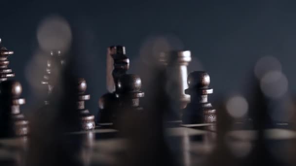 Gra planszowa inteligencja - szachy drewniane. Widok z bliska na figury na szachownicy obracające się zgodnie z ruchem wskazówek zegara na ciemnym tle. Rozwiązania biznesowe, wyzwania, sport, koncepcja strategii sukcesu. — Wideo stockowe