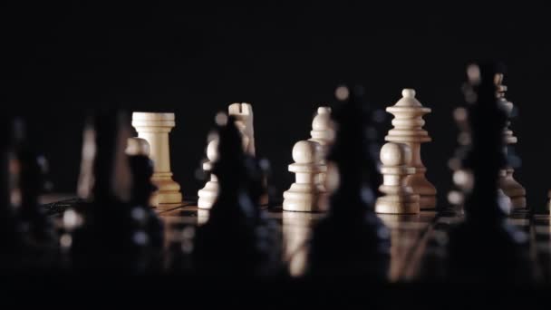나무 체스 판에 있는 체스 말을 인형으로 찍었습니다. 보드 전략 게임. 팀워크, 성공 사업, 정보 스포츠 개념. 흑색 배경. — 비디오