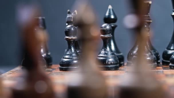 Dolly shot of old vintage chess pieces on wooden chessboard. Board strategy game. Focus on black. Teamwork, success business, intelligence sport concept. — Stock Video