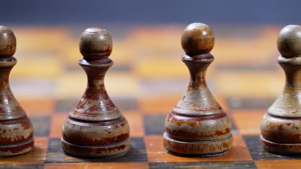 Anciens pions d'échecs sur un échiquier en bois. Jeu de stratégie. Concentrez-vous sur les figures blanches minables debout dans la rangée. Travail d'équipe, succès, intelligence concept sportif. — Video