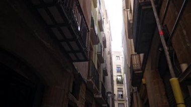 Steadicam shot: Barcelona Gotik Mahallesi 'nde balkonları olan evin dışı. Avrupa 'nın dar sokaklarındaki ortaçağ apartmanlarının cepheleri. Seyahat kavramı. 