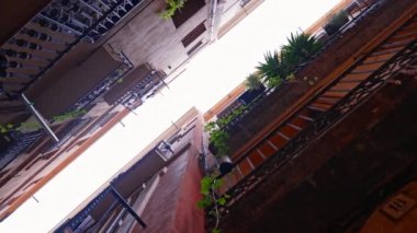 İspanya 'daki renkli evlerin cepheleri. Seyahat konsepti. Evin dışı, Barselona Gotik Mahallesi 'nde bitkilerle dolu balkonlar. Dar sokaktaki eski apartmanlar