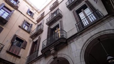 Steadicam shot: Barcelona Gotik Mahallesi 'nde balkonları olan evin dışı. Avrupa 'nın dar sokaklarındaki ortaçağ apartmanlarının cepheleri. Seyahat kavramı. 