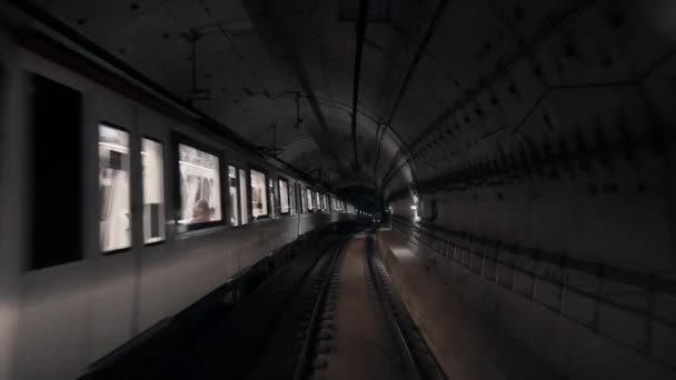 Вид подземного тоннеля от движущегося подземного вагона. Медленное движение поездов метро в столичном городе. Видеозапись современного общественного транспорта в Барселоне — стоковое видео