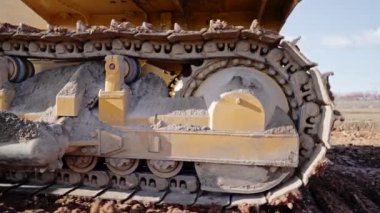 İnşaat alanında ya da taş ocağında çalışan buldozerin izini sürüyorum. Maden makineleri kil taşır, yeni yol için çakıl yüzeyini düzleştirir. Toprak taşıma, kazı, toprak kazma..