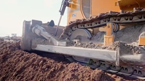 Tracking shot of crawler bulldozer working on construction site or quarry. Maquinaria de minería de arcilla móvil, suavizar la superficie de grava para la nueva carretera. Movimiento de tierras, excavaciones, excavaciones en suelos. — Vídeo de stock