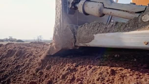 Tracking shot van crawler bulldozer werken op bouwplaats of steengroeve. Mijnbouw machines bewegende klei, gladstrijken grind oppervlak voor nieuwe weg. Grondverzet, opgravingen, graven op bodems. — Stockvideo