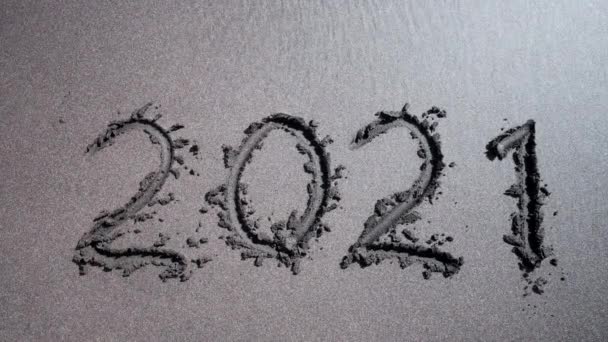 Viszlát 2021 év írva fekete homokos tengerparton, elmosta a tenger vagy óceán hulláma. Boldog újévi ünnepséget! trópusi sziget nyaralás. — Stock videók
