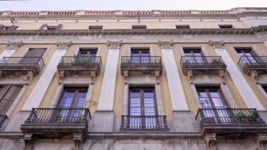 Barcelona 'nın eski bölümlerinde balkonları olan antik apartman binaları. Gotik Mahalle, Doğma Bölgesi. Yürüyen adamın sabit pozu. Popüler seyahat hedefi. 