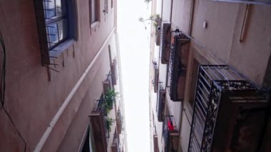 Barcelona 'nın Gotik Mahallesi' nde yeşil balkonları olan eski apartmanlar. Popüler seyahat yeri. Yürüyen kişinin öznel sabit görüntüsü.