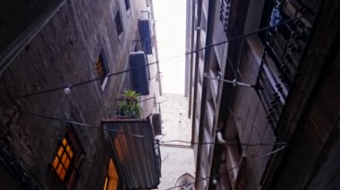 Barcelona 'nın eski bölümlerinde balkonları olan antik apartman binaları. Gotik Mahalle, Doğma Bölgesi. Yürüyen adamın sabit pozu. Popüler seyahat hedefi. 