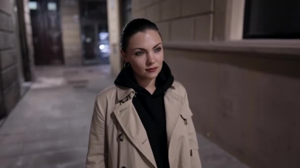 Jeune femme marchant dans la rue vide la nuit. Jolie dame en trench coat va à la réunion. Mode de vie urbain. — Video