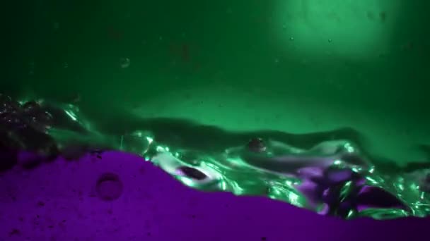 Piękna mieszanka zielonych i fioletowych cieczy o różnej gęstości w akwarium. Abstrakcja barwnego płynu mieszającego w zwolnionym tempie. Abstrakcyjny kolorowy design. — Wideo stockowe
