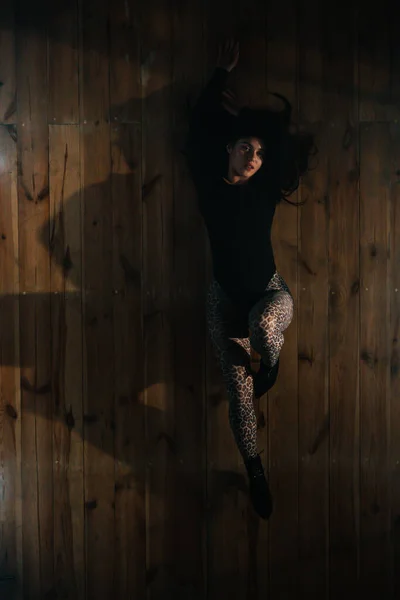 Bovenaanzicht op sexy vrouw liggend op de vloer. Verleidelijke dans in de studio. Vrouwendanser in strakke kleren en hoge hakken. Bovenaanzicht. — Stockfoto