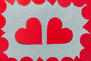 Kağıt kırmızı kalpler düz yerde yatıyordu. Sevgililer Günü kutlamaları, gümüş parıltılı arka plandaki desen çerçevesi. Aşk, romantizm, tebrik kartı