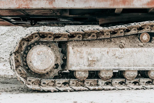 Crawler graafmachine onderstel close-up. Bulldozer werkt op bouwplaats of steengroeve. Mijnbouw machines verplaatsen klei, gladstrijken grind oppervlak voor de weg. Grondverzet, opgravingen, graven op bodems. — Stockfoto