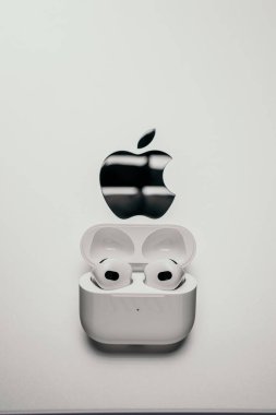Barselona, İspanya - Ocak 2022. Elma logosu beyaz arka planında kablosuz şarj davasında yeni hava podları uzmanı. Kulaklıklar, dikey fotoğraf, kopyalama alanı. Müzik, teknoloji, elektronik konsept