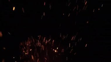 Koyu arkaplanda ateşten kıvılcımlar. Alevler geceleri yanıyor. Felaket, sorunlar, orman yangını kavramı. Güzel tehlikeli soyut.