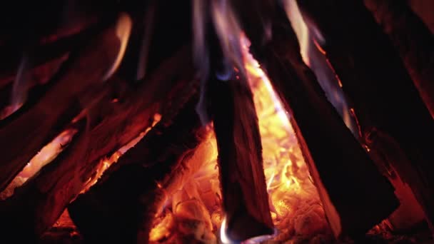 Api unggun yang mempesona dalam gerakan lambat. Banyak percikan api dan lidah api dari kayu yang terbakar. Api unggun, perapian, latar belakang energi api. — Stok Video