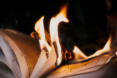 Açık kitap yanıyor, sayfalar alevler içinde. Sansür kavramı, özgürlük bilgisi yasağı, 451 fahrenhayt, kağıt formatında eski edebiyat artık talep görmüyor.