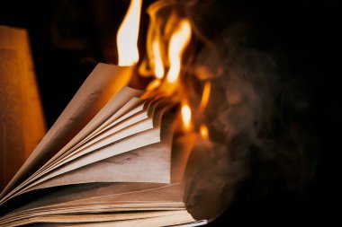 Açık kitap yanıyor, sayfalar alevler içinde. Sansür kavramı, özgürlük bilgisi yasağı, 451 fahrenhayt, kağıt formatında eski edebiyat artık talep görmüyor.