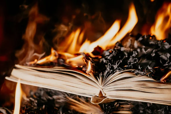 Le livre ouvert est en feu, les pages sont englouties dans les flammes. Notion de censure, interdiction de la liberté de l'information, 451 fahrenheit, littérature ancienne en format papier n'est plus en demande. — Photo
